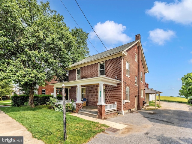 19330 Longmeadow Rd, Hagerstown, MD 21742 - traditional style home with a porch, a chimney, brick siding, and a front yard