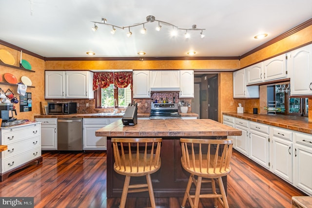 400 Berry Mountain Rd, Millersburg, PA 17061 - kitchen with stainless steel appliances, a sink, dark wood-style floors, a kitchen island, and crown molding