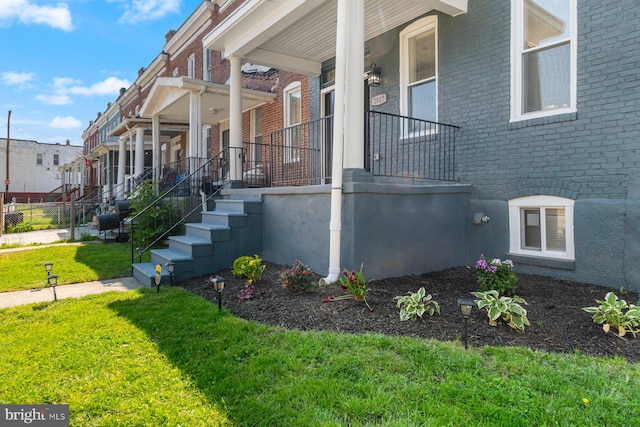 2817 Waldorf Ave, Baltimore, MD 21215 - view of side of home featuring covered porch, brick siding, and a lawn