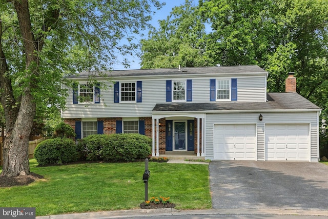 14612 Orangewood St, Silver Spring, MD 20905 - view of front of home featuring driveway, a front lawn, brick siding, and a chimney