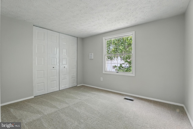 14612 Orangewood St, Silver Spring, MD 20905 - unfurnished bedroom featuring carpet flooring, a closet, a textured ceiling, and baseboards
