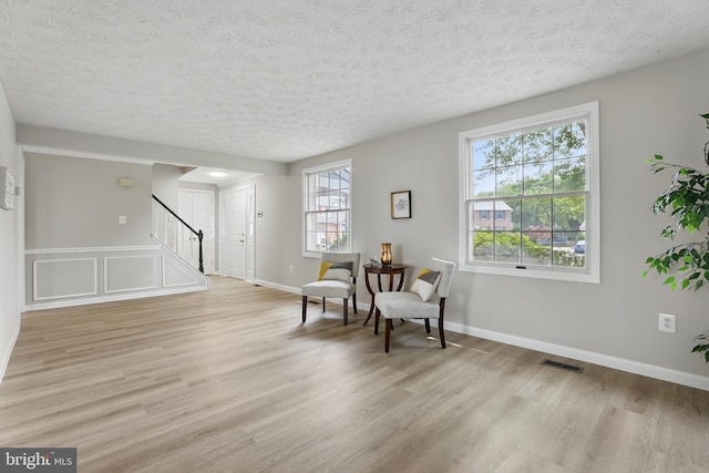 14612 Orangewood St, Silver Spring, MD 20905 - living area with stairway, light wood finished floors, a textured ceiling, and baseboards
