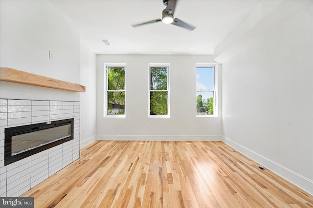 1630 E Biddle St, Baltimore, MD 21213 - unfurnished living room featuring a tiled fireplace, wood finished floors, baseboards, and ceiling fan