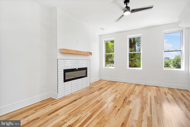1630 E Biddle St, Baltimore, MD 21213 - unfurnished living room with a tiled fireplace, wood finished floors, baseboards, and ceiling fan