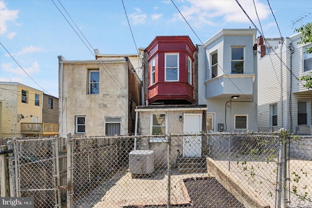 1630 E Biddle St, Baltimore, MD 21213 - multi unit property featuring stucco siding, a gate, and central AC unit