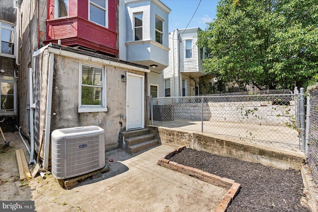 1630 E Biddle St, Baltimore, MD 21213 - rear view of house with central AC, entry steps, and stucco siding