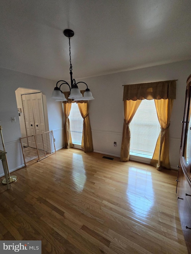 5546 Neddleton Ave, Woodbridge, VA 22193 - unfurnished dining area with a chandelier, plenty of natural light, wood finished floors, and baseboards
