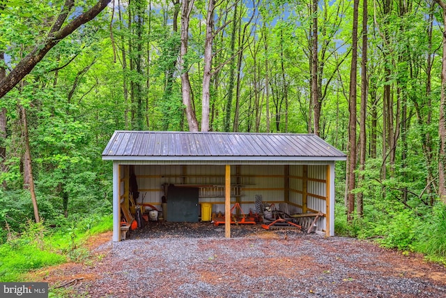 4441 Solomons Island Rd, Harwood, MD 20776 - garage featuring a carport, a wooded view, and driveway