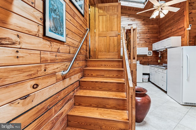 4441 Solomons Island Rd, Harwood, MD 20776 - staircase featuring wooden walls, ceiling fan, tile patterned floors, washer / dryer, and a skylight