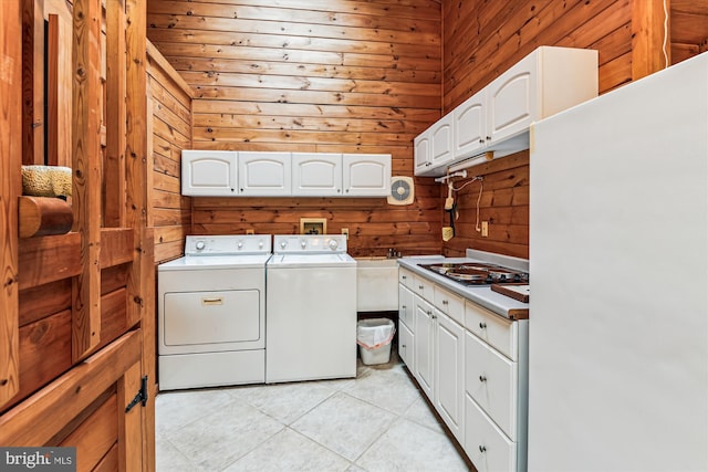 4441 Solomons Island Rd, Harwood, MD 20776 - laundry area featuring washing machine and clothes dryer, wood walls, and light tile patterned floors