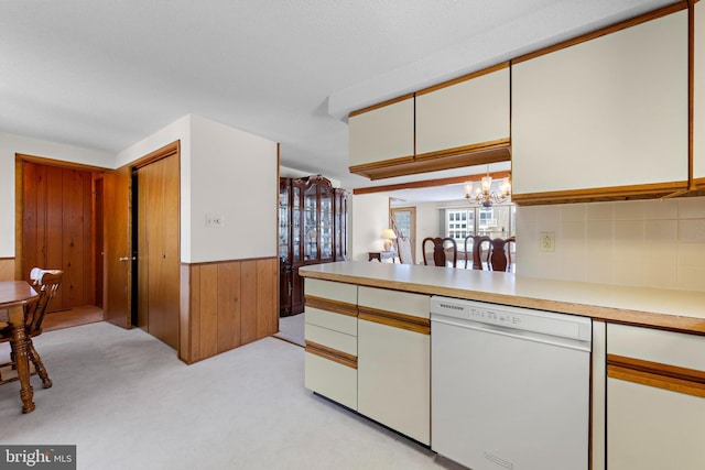 18 Old Whaling Ln, Long Beach Township, NJ 08008 - kitchen with white dishwasher, a chandelier, wooden walls, light countertops, and a wainscoted wall