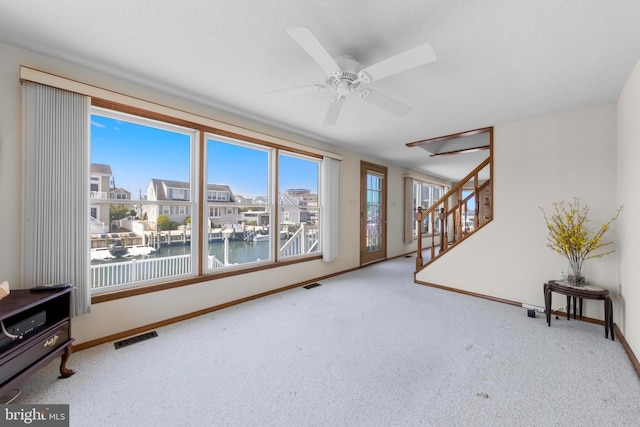 18 Old Whaling Ln, Long Beach Township, NJ 08008 - unfurnished living room with stairs, carpet, a water view, a ceiling fan, and a residential view