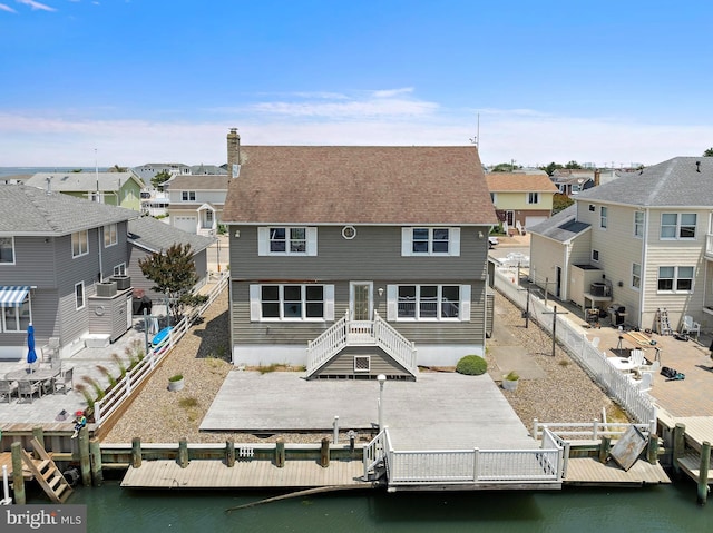 18 Old Whaling Ln, Long Beach Township, NJ 08008 - back of property with a residential view, a chimney, a water view, a fenced backyard, and roof with shingles