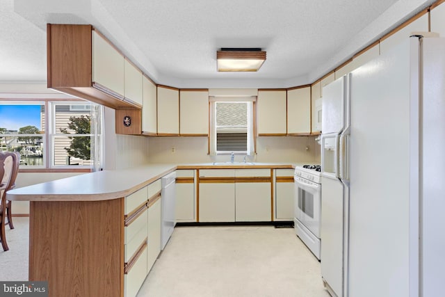 18 Old Whaling Ln, Long Beach Township, NJ 08008 - kitchen featuring white appliances, a peninsula, decorative backsplash, a textured ceiling, and light countertops