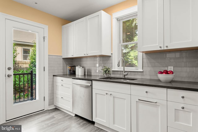 303 Conway Ave, Narberth, PA 19072 - kitchen with stainless steel dishwasher, a sink, dark countertops, and white cabinetry