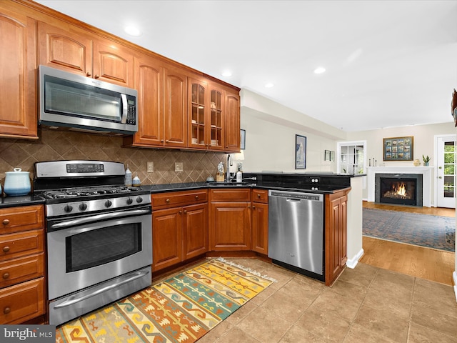 2772 Gingerview Ln, Annapolis, MD 21401 - kitchen with appliances with stainless steel finishes, a sink, dark countertops, brown cabinetry, and a peninsula