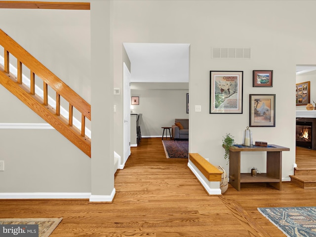 2772 Gingerview Ln, Annapolis, MD 21401 - foyer entrance featuring stairs, wood finished floors, a glass covered fireplace, and baseboards
