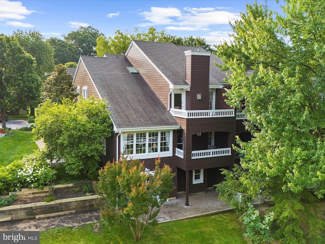 2772 Gingerview Ln, Annapolis, MD 21401 - back of property featuring a patio, a shingled roof, a balcony, a chimney, and a lawn