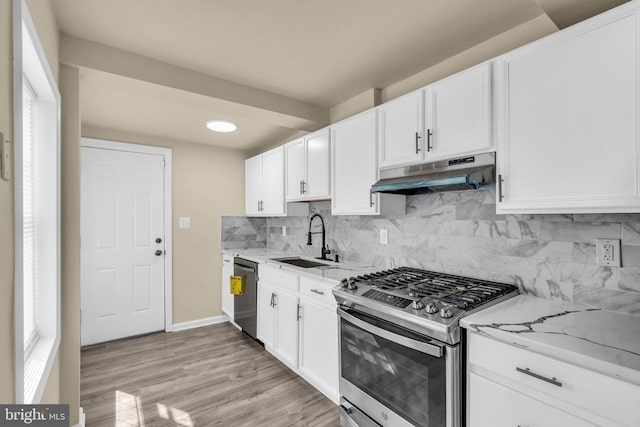 2923 Wasp Rd, Camden, NJ 08104 - kitchen with appliances with stainless steel finishes, under cabinet range hood, a sink, light stone countertops, and white cabinets