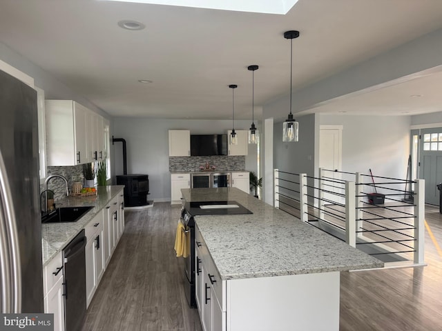 448 Carvel Beach Rd, Carvel Beach, MD 21226 - kitchen with a sink, a wood stove, stainless steel appliances, decorative backsplash, and white cabinetry