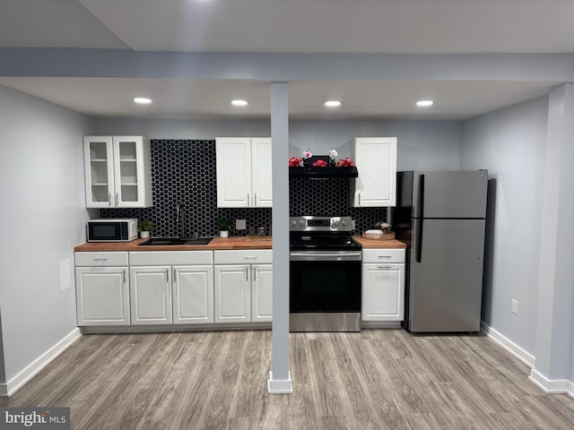 448 Carvel Beach Rd, Carvel Beach, MD 21226 - kitchen with appliances with stainless steel finishes, wood counters, light wood-style flooring, white cabinets, and recessed lighting