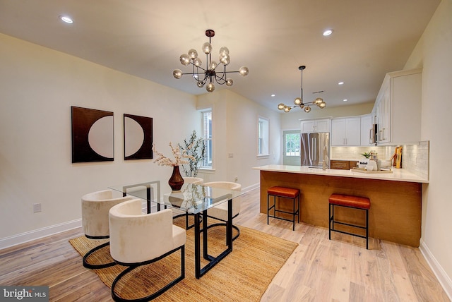 4938 Walton Ave, Philadelphia, PA 19143 - dining space featuring a chandelier, light wood finished floors, and recessed lighting
