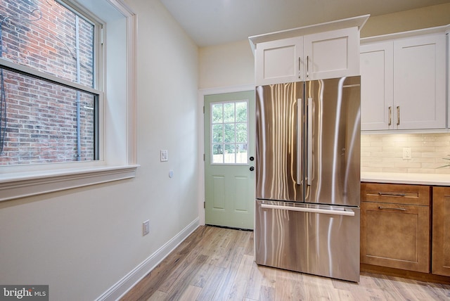 4938 Walton Ave, Philadelphia, PA 19143 - kitchen with freestanding refrigerator, light wood-style flooring, tasteful backsplash, light countertops, and white cabinets