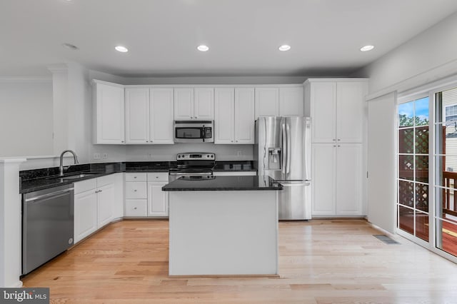 5454 Patuxent Knoll Pl, Alexandria, VA 22312 - kitchen featuring appliances with stainless steel finishes, a sink, white cabinets, a kitchen island, and light wood finished floors