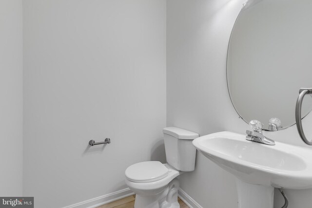 5454 Patuxent Knoll Pl, Alexandria, VA 22312 - half bathroom with baseboards, toilet, wood finished floors, and a sink