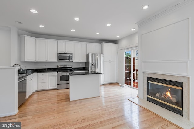 5454 Patuxent Knoll Pl, Alexandria, VA 22312 - kitchen featuring stainless steel appliances, white cabinets, a fireplace, a center island, and recessed lighting
