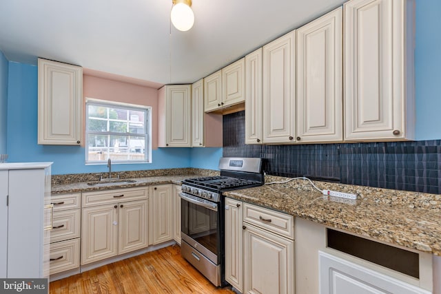 3826 W Bay Ave, Baltimore, MD 21225 - kitchen with stainless steel gas range oven, a sink, light wood finished floors, tasteful backsplash, and stone counters