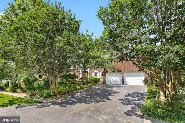 4920 Sunset Ln, Annandale, VA 22003 - obstructed view of property with brick siding, asphalt driveway, and a garage
