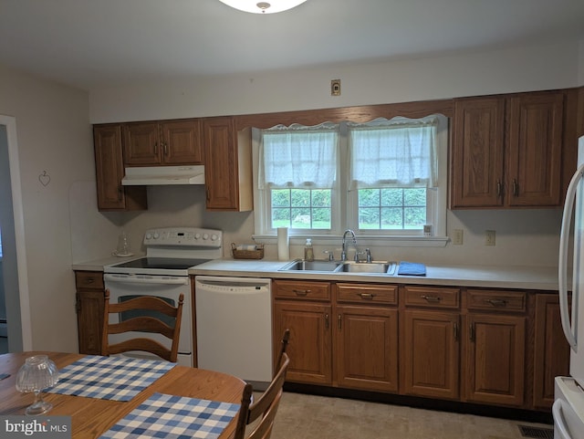 3339 Bruun Ave, Vineland, NJ 08360 - kitchen with white appliances, under cabinet range hood, light countertops, and brown cabinetry