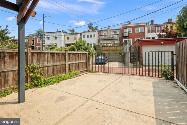 1360 Perry Pl NW, Washington, DC 20010 - view of patio / terrace featuring a residential view, concrete driveway, a gate, and a garage