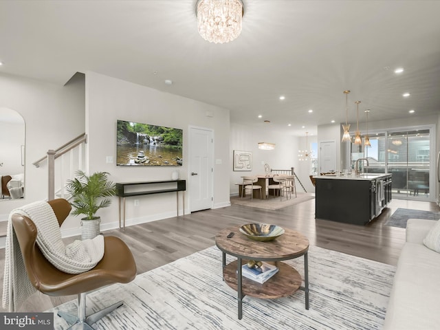 7330 Isabella Rd, Laurel, MD 20723 - living area with a chandelier, wood finished floors, recessed lighting, arched walkways, and stairs