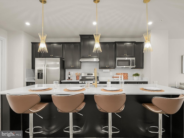 7330 Isabella Rd, Laurel, MD 20723 - kitchen with appliances with stainless steel finishes, under cabinet range hood, a center island with sink, light countertops, and a breakfast bar