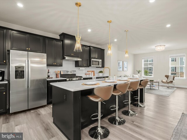 7330 Isabella Rd, Laurel, MD 20723 - kitchen with appliances with stainless steel finishes, an island with sink, recessed lighting, light countertops, and under cabinet range hood