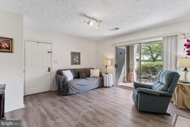 20273 Beechwood Ter Unit 103, Ashburn, VA 20147 - living area featuring wood finished floors, a textured ceiling, and rail lighting