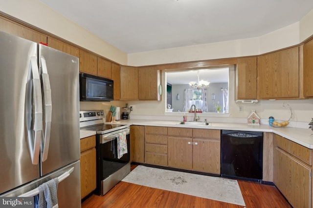 226 Troon Ct, Royersford, PA 19468 - kitchen with black appliances, dark wood-style floors, a chandelier, and light countertops