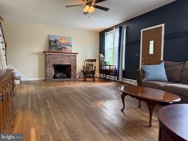 2329 Canby St, Harrisburg, PA 17103 - living area with wood finished floors, a ceiling fan, stairs, a fireplace, and baseboards