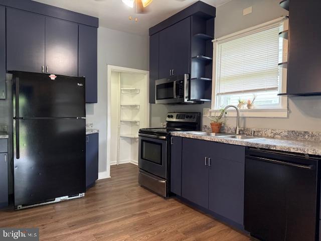2329 Canby St, Harrisburg, PA 17103 - kitchen with black appliances, open shelves, a sink, wood finished floors, and blue cabinets