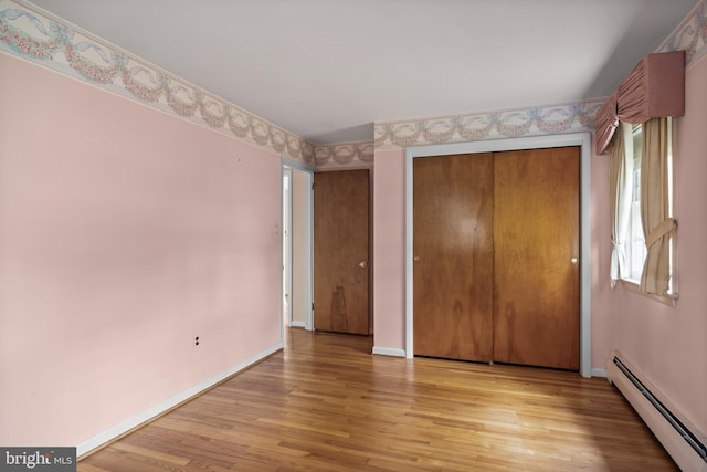 1101 Cherry Ln, Cinnaminson, NJ 08077 - unfurnished bedroom with baseboard heating, light wood-style flooring, baseboards, and a closet