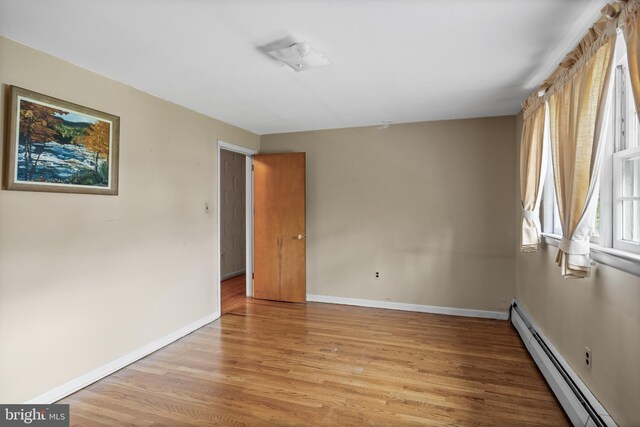 1101 Cherry Ln, Cinnaminson, NJ 08077 - spare room with a baseboard heating unit, light wood finished floors, and baseboards
