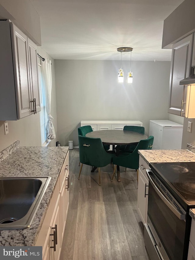 9031 Continental Pl, Landover, MD 20785 - kitchen featuring stainless steel electric range oven, a sink, wood finished floors, fridge, and light stone countertops
