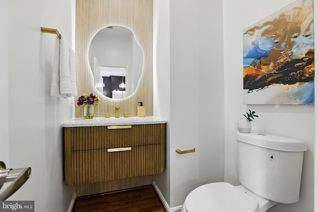 402 Woodcrest Dr SE, Washington, DC 20032 - half bath with toilet, wood finished floors, vanity, baseboards, and tasteful backsplash