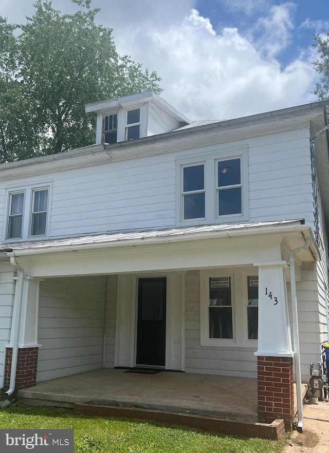 143 N 2nd St, Mount Wolf, PA 17347 - view of front of house featuring covered porch and brick siding