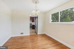 5729 Nevada St, Berwyn Heights, MD 20740 - unfurnished dining area with healthy amount of natural light, a chandelier, and baseboards
