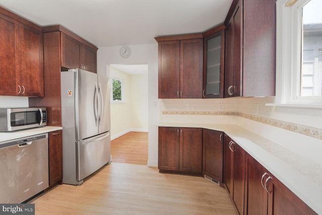 5729 Nevada St, Berwyn Heights, MD 20740 - kitchen with stainless steel appliances, light wood-type flooring, light countertops, backsplash, and glass insert cabinets