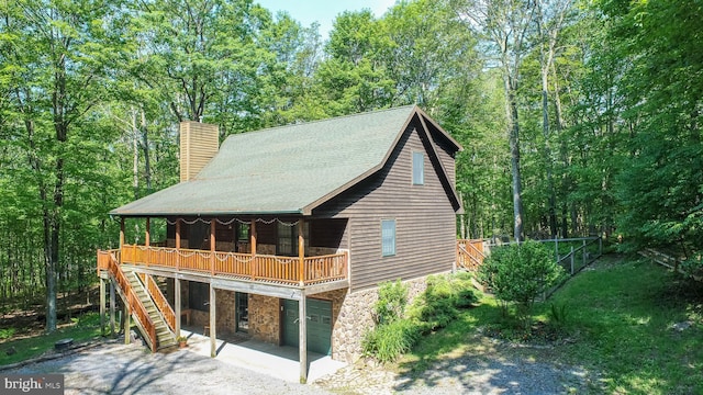 129 Bucks Crossing Ln, Accident, MD 21520 - view of front of home with stone siding, a chimney, gravel driveway, a garage, and stairway