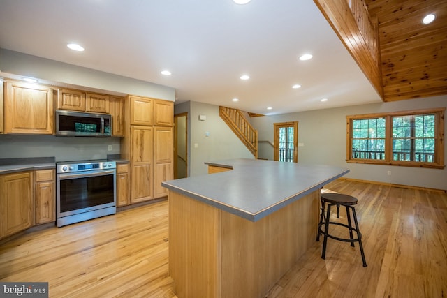 129 Bucks Crossing Ln, Accident, MD 21520 - kitchen featuring appliances with stainless steel finishes, recessed lighting, a breakfast bar area, light wood-style flooring, and dark countertops